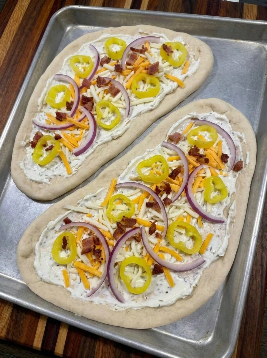 Banana peppers and cheese layered on flatbread