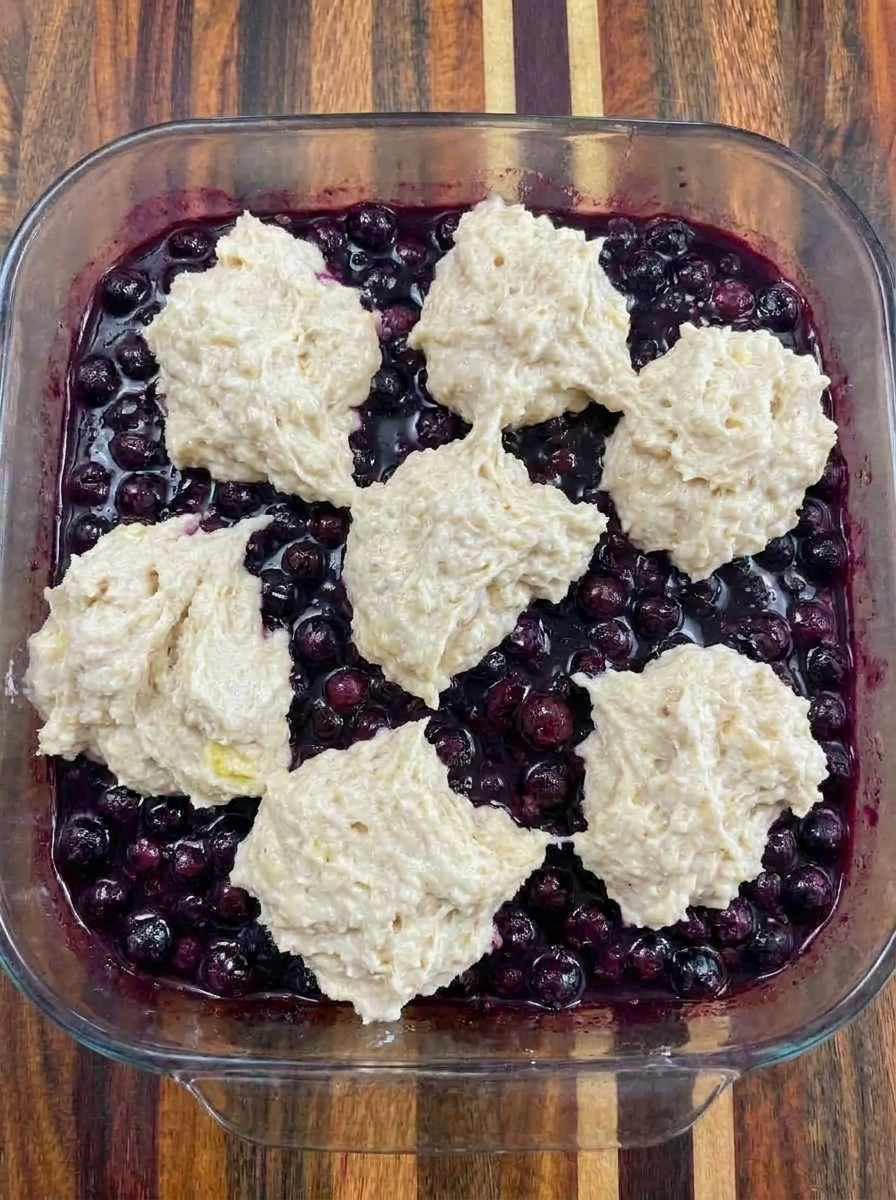 Huckleberry filling topped with cobbler batter before baking