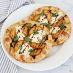 Peach Burrata Flatbread with melted burrata and peaches and basil