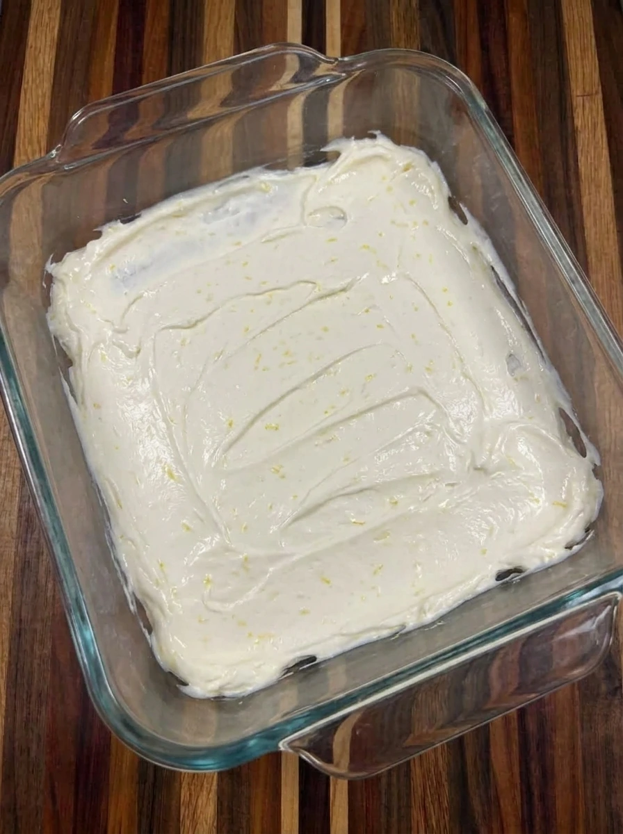 First cream layer spread in dish for Raspberry Icebox Cake