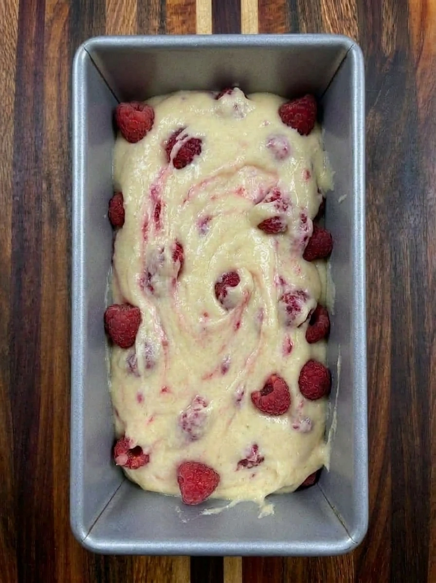 Raspberry lemon batter poured into a loaf pan