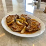 Apple Butter Pork Chops with browned edges and tender apple slices in a glossy skillet sauce
