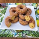 Apple Cider Donuts coated in cinnamon sugar on a white plate