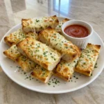 Golden Cheesy Garlic Bread Dippers with melted mozzarella and warm marinara