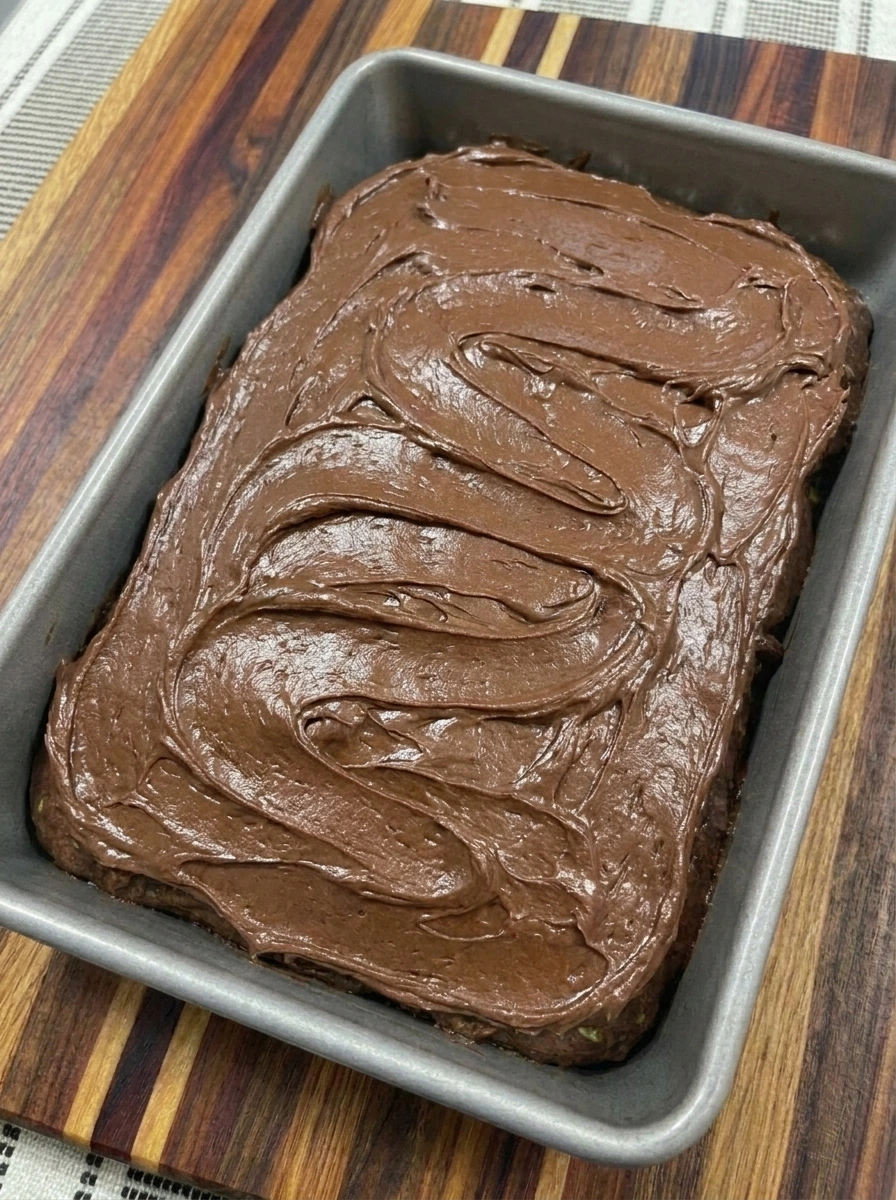 Chocolate Zucchini Cake covered with uneven swirls of cocoa frosting