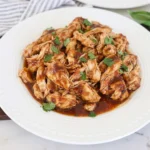 Tender shredded Crockpot BBQ Chicken coated in glossy smoky barbecue sauce