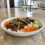 Crockpot Korean BBQ Beef over rice with carrots cucumber green onions and sesame seeds
