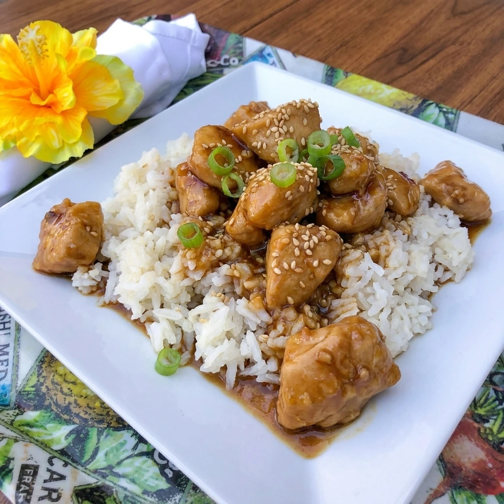 Crockpot Sesame Chicken served over rice with sesame seeds and green onions