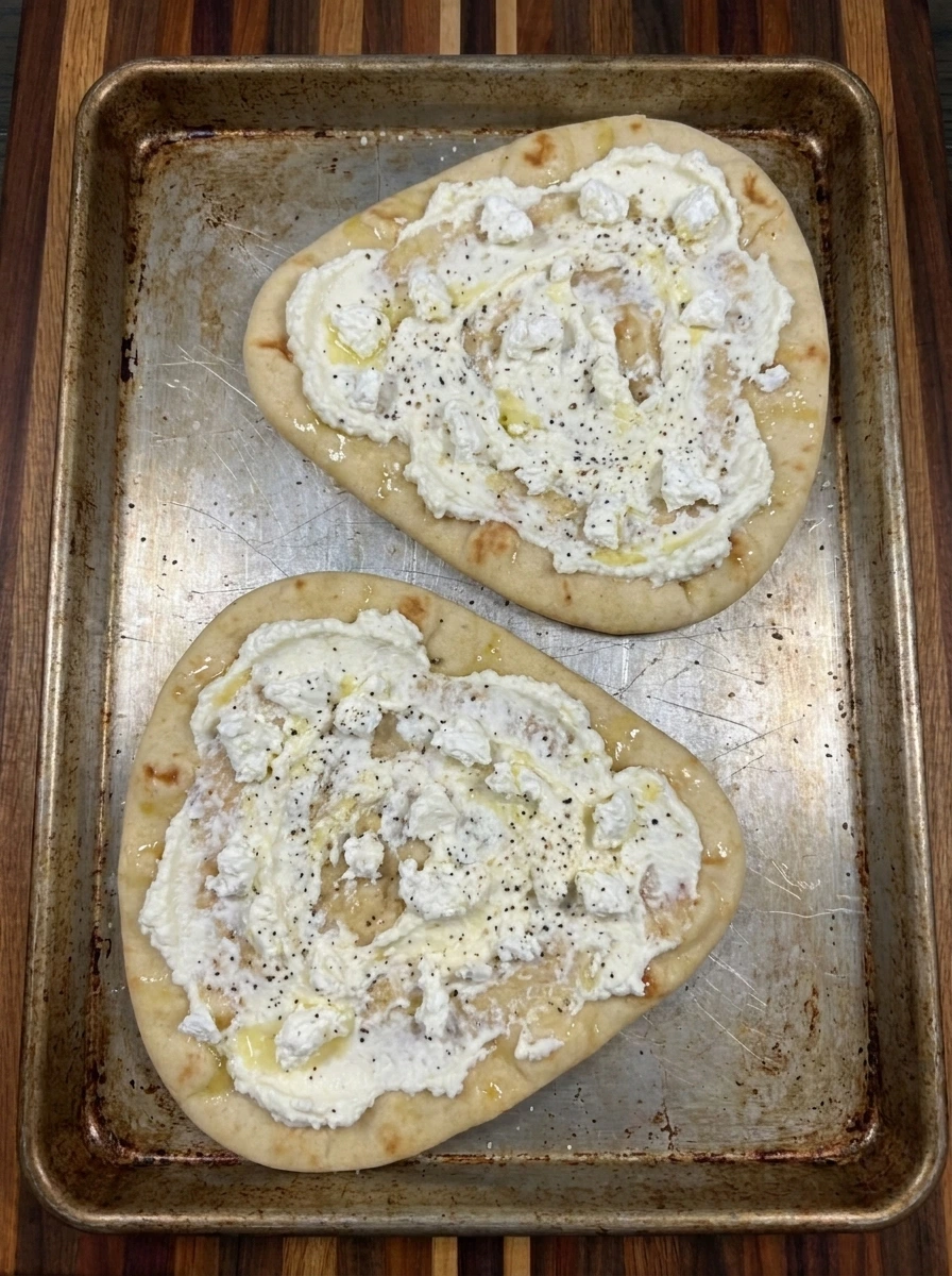 Ricotta and goat cheese spread on two naan flatbreads