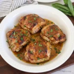 Maple Dijon Chicken Thighs with glossy browned skin and herb garnish