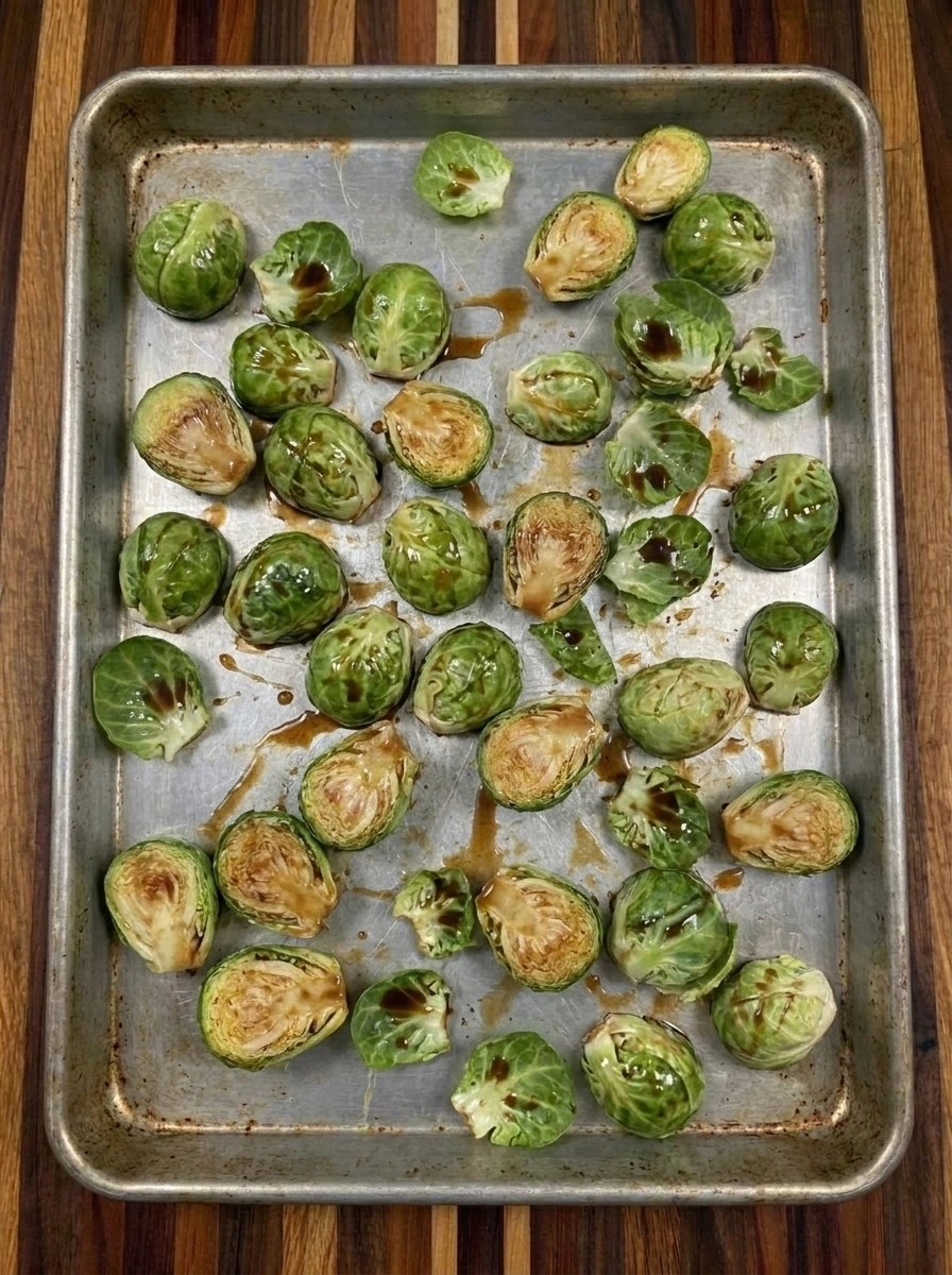 Coated Brussels sprouts spread on a sheet pan