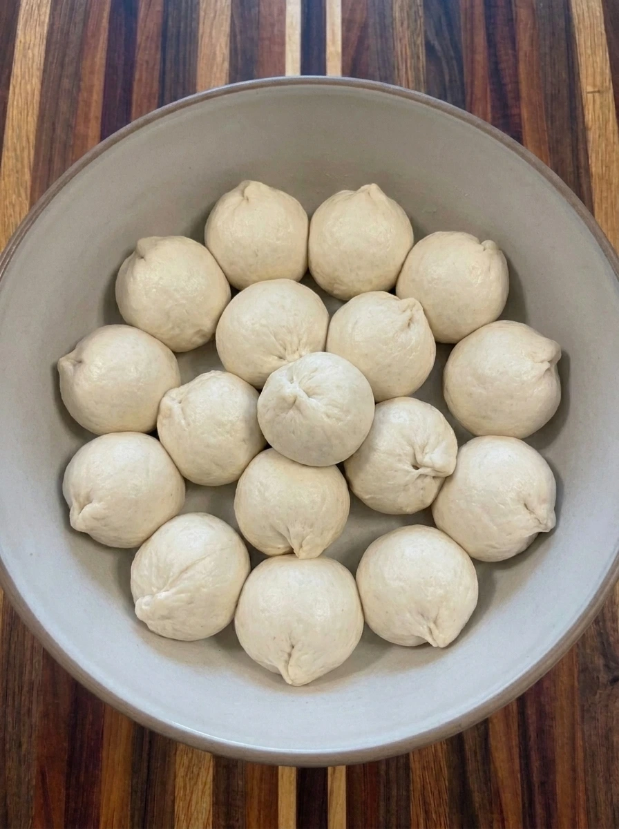 Sixteen dough balls wrapped around mozzarella cubes