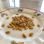 Golden Oven Roasted Pumpkin Seeds served on a plate with crisp toasted edges