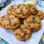 Pumpkin Chocolate Chip Cookies stacked on a plate with melted chocolate chips