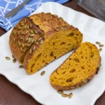Golden pumpkin sourdough bread loaf with sliced orange crumb