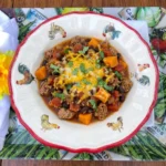 Sweet Potato Turkey Chili in a bowl with turkey beans sweet potatoes and melted cheese