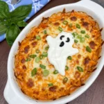 Halloween Boo-ffalo Chicken Dip with melted cheese and a sour cream ghost