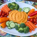 Halloween Veggie Tray with Pumpkin Dip arranged on a large serving platter