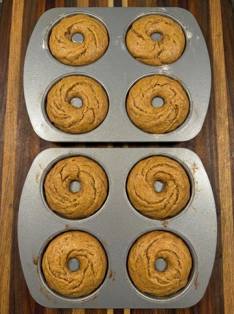 Eight baked pumpkin spice donuts with lightly browned edges