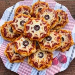 Spiderweb Pizza Bites with melted mozzarella webs and olive centers
