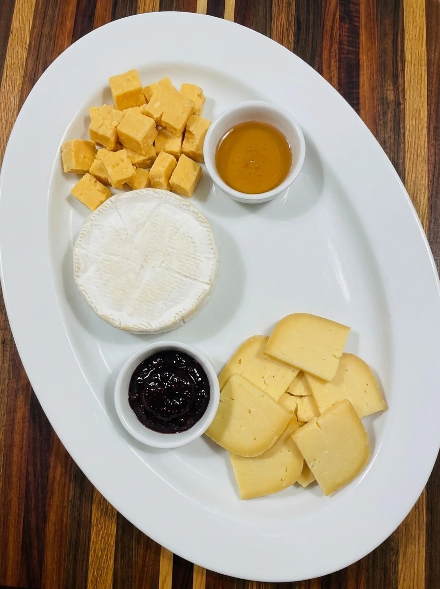 Brie and cheddar plus Gouda arranged on an Autumn Charcuterie Board with fig jam and honey