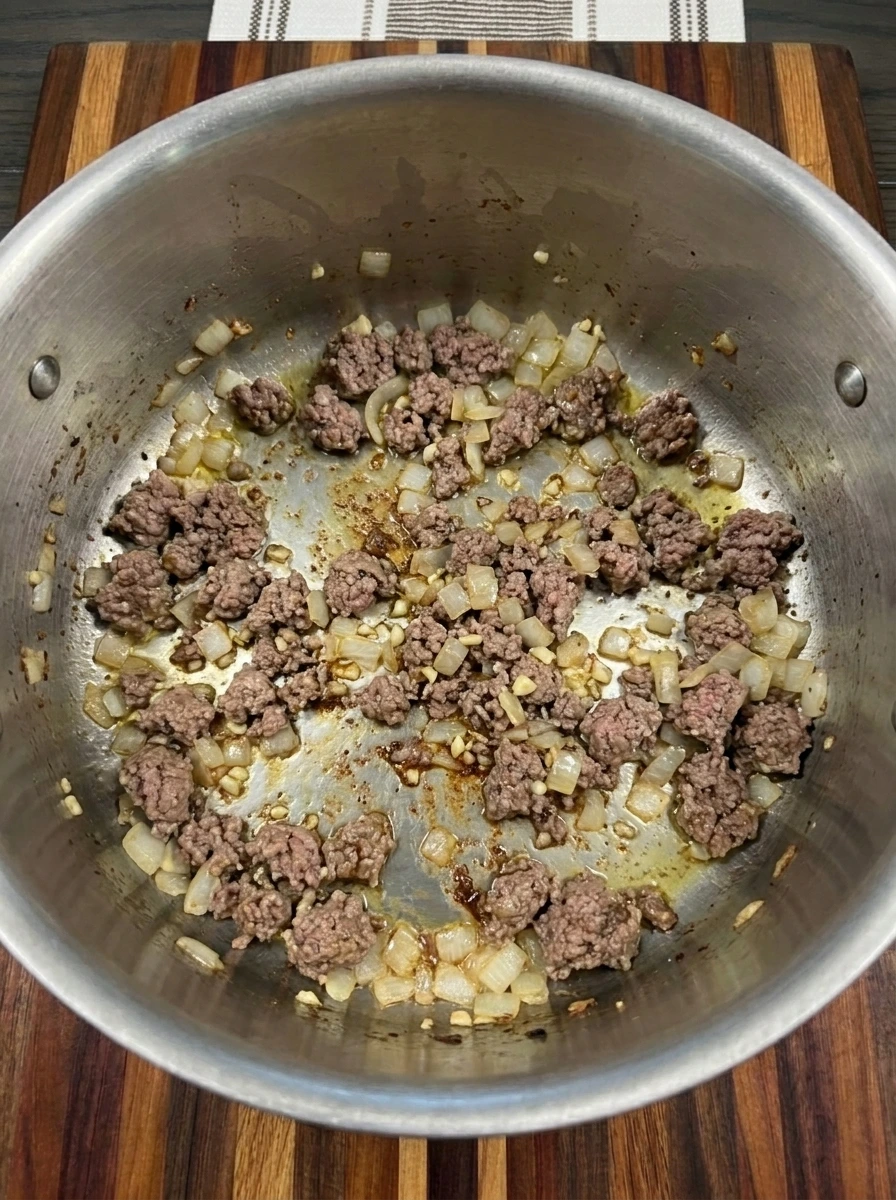 Browned ground beef with softened onion and garlic in a large pot for Cabbage Roll Soup