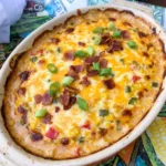 Cowboy Corn Dip with sweet corn and golden melted cheese and smoky bacon in a ceramic serving dish