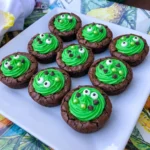 Halloween Cauldron Cookies filled with green frosting and candy eyeballs