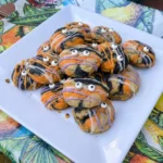Homemade Halloween Cookies with orange and black marbling plus colorful icing and candy eyes