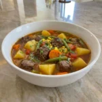 Homemade Old-Fashioned Vegetable Beef Soup with tender beef and potatoes and carrots in a rich tomato broth.