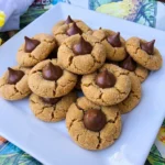Homemade Peanut Butter Blossoms with chocolate kisses on golden sugar-coated peanut butter cookies arranged on a white serving plate