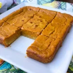 Homemade Pumpkin Gooey Butter Cake with a golden buttery crust and creamy pumpkin filling in a baking dish