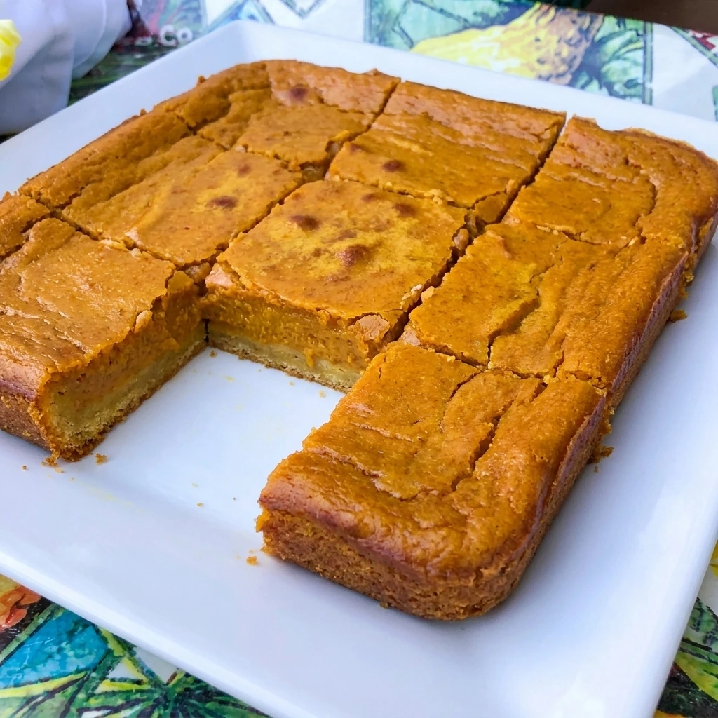 Homemade Pumpkin Gooey Butter Cake with a golden buttery crust and creamy pumpkin filling in a baking dish