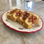 Sándwiches Ataúd Terroríficos with melted cheese and ketchup crosses